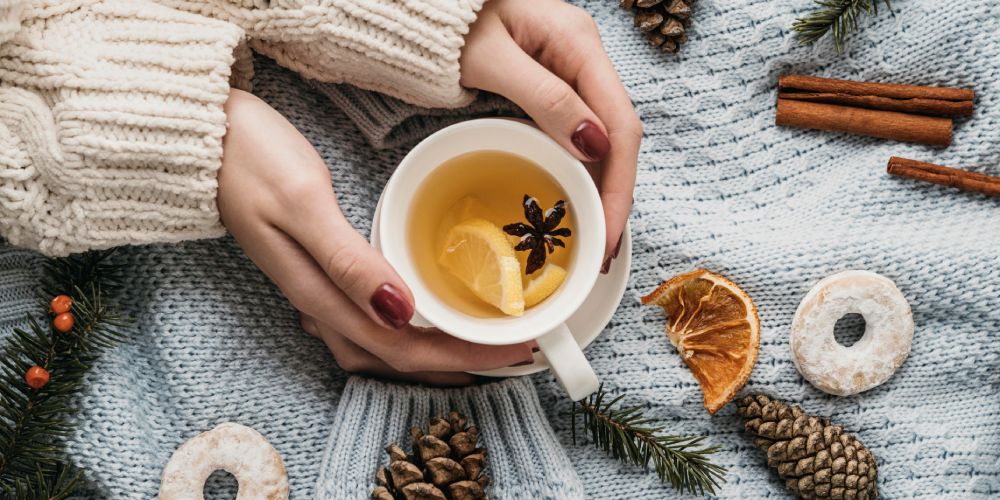 mains qui tiennent une tasse de thé avec de l'anis